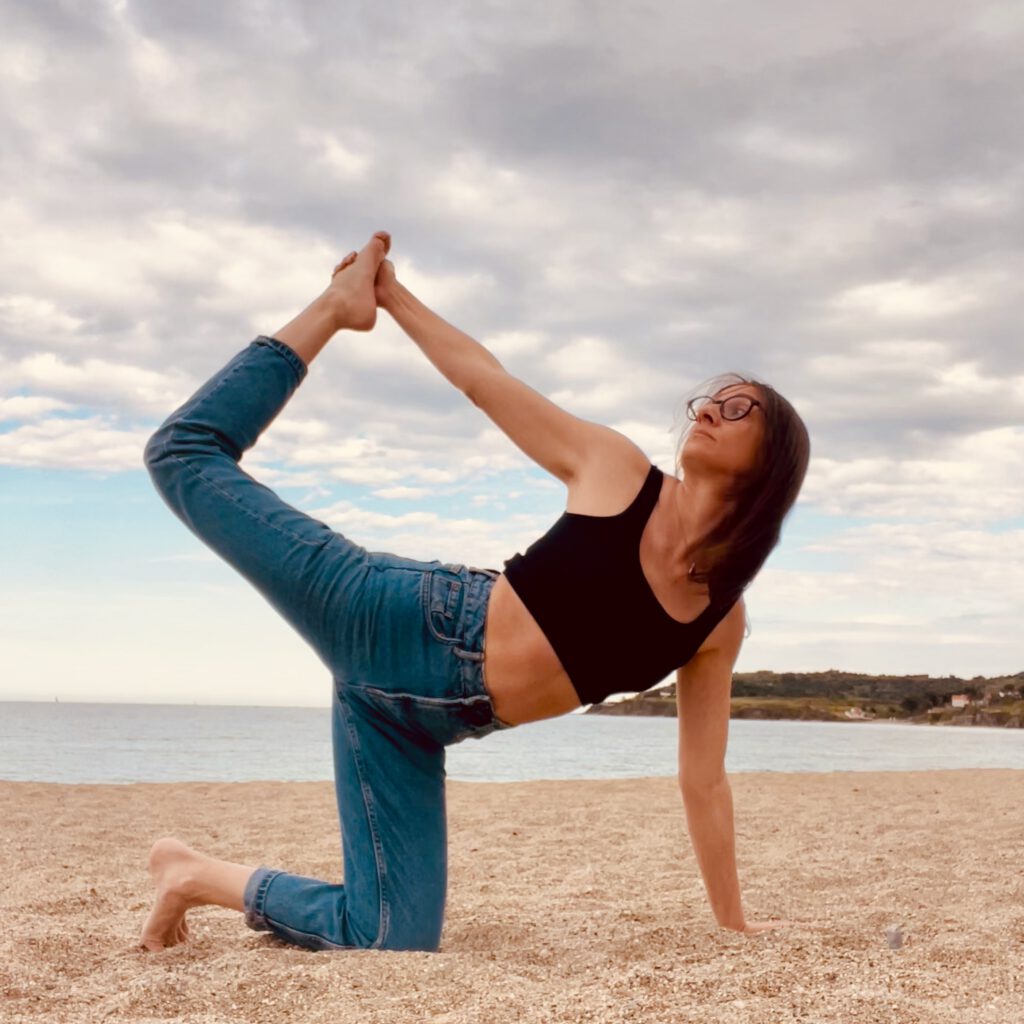 Professeure de yoga à Toulouse dans une variante de la posture du roi de la danse.